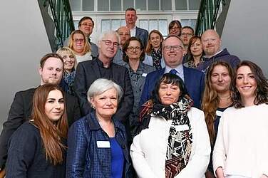 Die Teilnehmer des ersten Kurses (li. u. re.) sowie Andrea Osterhus (Leitung Ausbildungs-zentrum), Birgit Krukemeier (Pflegedirektorin Psychiatrien, beide erste Reihe), Uwe Blanke (Region Hannover), Michael Born (KRH Geschäfts-führung, beide zweite Reihe), Lucie Hüttermann (Kursleitung, dritte Reihe), Mathias Wolf (Leitung Weiterbildung) Dagmar Schlösser (beide vierte Reihe) und Michael Sandau (Kursleitung, hinterste Reihe).