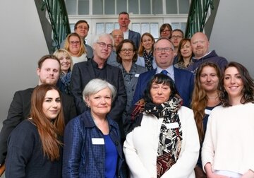 Die Teilnehmer des ersten Kurses (li. u. re.) sowie Andrea Osterhus (Leitung Ausbildungs-zentrum), Birgit Krukemeier (Pflegedirektorin Psychiatrien, beide erste Reihe), Uwe Blanke (Region Hannover), Michael Born (KRH Geschäfts-führung, beide zweite Reihe), Lucie Hüttermann (Kursleitung, dritte Reihe), Mathias Wolf (Leitung Weiterbildung) Dagmar Schlösser (beide vierte Reihe) und Michael Sandau (Kursleitung, hinterste Reihe).