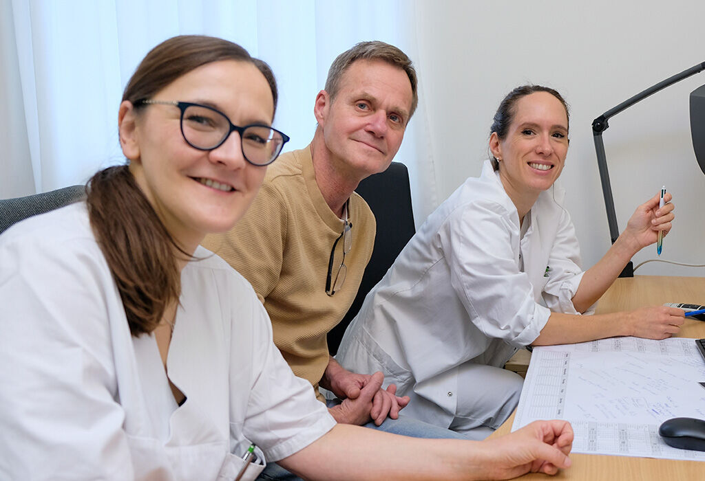 Von links nach rechts: Domenica Wuthe, Jens Nentwig und Dr. med. Isabelle Renger, schauen sich die Bilder des Tumors an (der graue Fleck auf der linken Seite des Monitors), in Rengers Büro im KRH Klinikum Siloah.