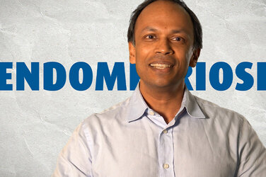 PD Dr. med. Sudip Kundu steht vor einer weißen Wand, hinter ihm steht in blau "Endometriose"