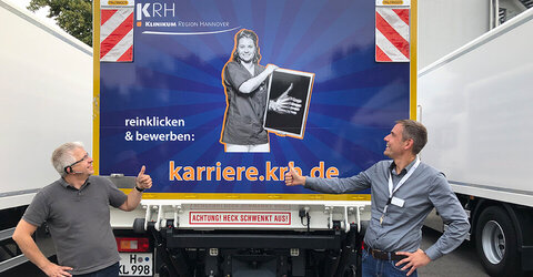 Auffälliger Werbeträger: Zwölf KRH-Trucks sind künftig mit Motiven der Karriere-Kampagne auf den Straßen der Region unterwegs. Den ersten beklebten LKW nehmen Sven Löscher (links), Güterverkehr, und Steffen Ellerhoff, Leiter Unternehmenskommunikation, in Augenschein.