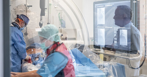 Eins der beiden neuen Labore im Einsatz – Chefarzt Prof. Dr. Marc Wilhelm Merx (r.)beobachtet aus dem Nachbarraum die Behandlung eines Herzpatienten.