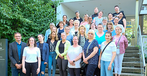 Teilnehmerinnen und Teilnehmer des Vorbereitungskurses Pflegeassistenz, Rüdiger Seifert (erste Person links), Schulleitung/Fachbereichsleitung Pflege und Assistenz der Dachstiftung Diakonie und Sina Gaebel (zweite Person links), Abteilungsleitung Personalentwicklung der KRH Akademie vor der KRH Akademie.