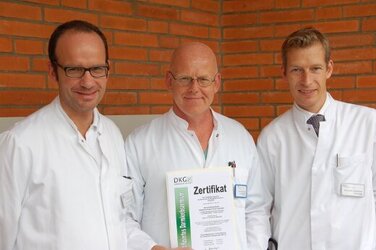 Oberarzt Dr. Trostdorf, Chefarzt Dr. Memming und Chefarzt PD Dr. Wedemeyer mit der Urkunde der deutschen Krebsgesellschaft