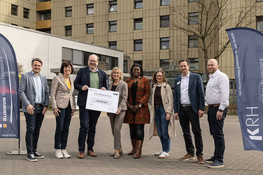Bescheidübergabe vor dem Bettenhaus des KRH Klinikum Neustadt am Rübenberge (von links): Dominic Herbst (Bürgermeister von Neustadt am Rübenberge), Ute Lamla (stellvertretende Regionspräsidentin), Christian Meyer (Niedersächsischer Minister für Umwelt, Energie und Klimaschutz), Barbara Schulte (KRH Geschäftsführerin Finanzen und Infrastruktur), Djenabou Diallo Hartmann (Landtagsabgeordnete), Sinja Münzberg (Aufsichtsratsmitglied KRH und Mitglied der Regionsversammlung), Markus Wolf (Geschäftsführender und Kaufmännischer Direktor des KRH Klinikum Neustadt am Rübenberge) und Frank Dödtmann (Energiemanagementbeauftragter des KRH).  