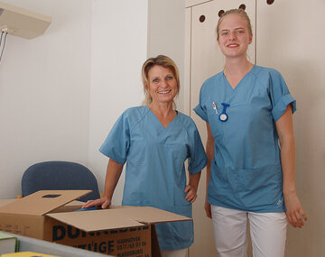 Stationsleiterin Manuela Schwäcke (links) und Pflegepraktikantin Lea Gandyra packen Kisten für den Umzug.