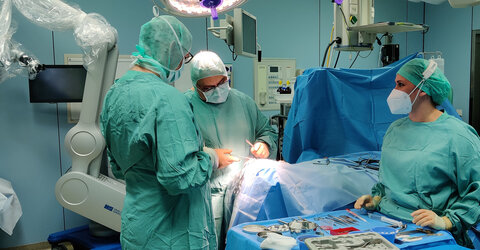 Prof. Dr. med. Arya Nabavi (Mitte) beim Zunähen einer offenen Kopfwunde, mit Schwester Sarah Domnick (rechts), Operationstechnische Assistentin.
