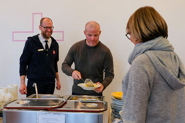 Steffen Aselmann (links) von der Heilsarmee Hannover und Michael Helms, Küchenleitung der KRH Zentralküche, bei der Essensausgabe in der Heilsarmee Hannover direkt am Leineufer in der hannoverschen Innenstadt.
