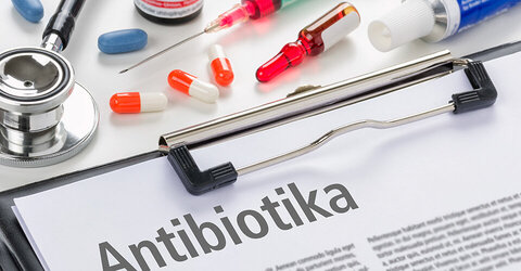 Auf dem Bild sind Medikamente zu sehen mit einem Klemmbrett, auf den "Antibiotika" steht