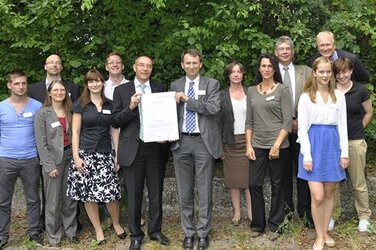 Auditor Lutz Böttcher, Bereichsleiter Thomas Melosch (mit der Zertifizierungs-Urkunde) und das Team des Bereichs UMV