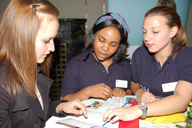 Die Pflege-Schülerinnen Hope Anyiam (Mitte) und Mirjam Flinte erklären die Ausbildungsmöglichkeiten im KRH.