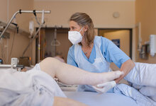 Physiotherapeutin Ulrike Irmer beginnt die Behandlung am Knie